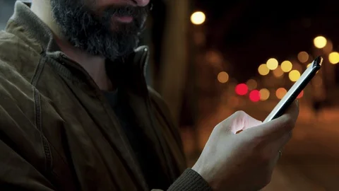 Bearded man texting sms message smartphone at night city street. Connecting and Video stock 128033205