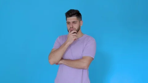 Bearded man thinking scratching head on blue background wearing t shirt Stock Footage 123944303