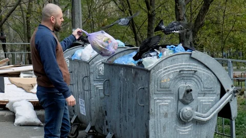 Bearded man throws garbage in the trash can and walks away Vidéo 107152747