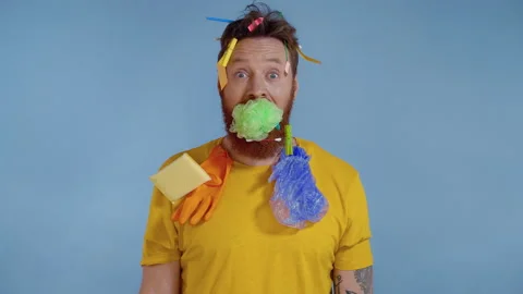 Bearded man with trash on him holding green wisp in the mouth. Video stock 146231159
