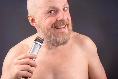 Bearded man with trimmer to adjust beard in hand. grooming and fashionable st Stock Photos