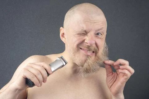 Bearded man with trimmer to adjust beard in hand. grooming and fashionable st Stock Photos