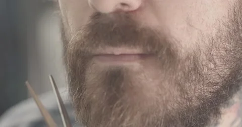 Bearded man trims mustache with scissors Video stock 134661729