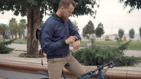 Bearded man is typing and doing voice command for smart watch, outdoors Stock Footage 101445904