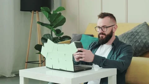 Bearded man typing a sms to his friend while is taking a break from working Stock Footage 156329649
