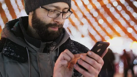 Bearded man use smartphone app, Christmas lights. Close-up shot Stock Footage 100181231