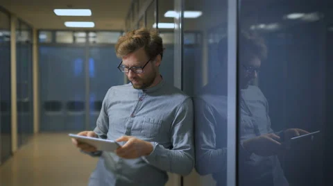 A bearded man uses a tablet computer.Businessman checks mail on a digital tablet Stock Footage 68624811