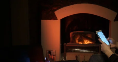 Bearded man uses a tablet near the fireplace sliding Stock Footage 88060277