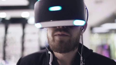 Bearded man uses VR-headset display with headphones for virtual reality game Video stock 69124492
