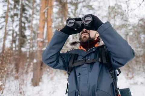 Bearded Man Using Binoculars While Winter Forest Trip Stock Photos
