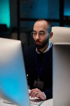 Bearded Man using Computer with Blue Lights Stock-Fotos