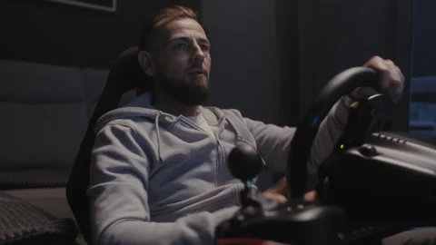 A bearded man using a driving simulator at home Stock Footage 258388625