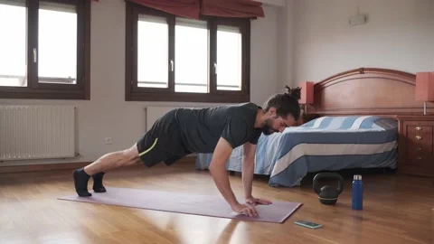 Bearded man using his mobile phone to exercise at home. Stock Footage 158487952