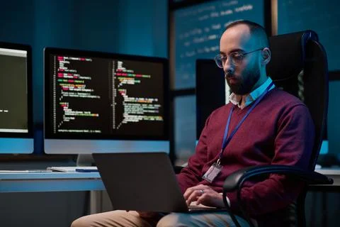 Bearded Man using Laptop at Office with Blue Light Stock-Fotos