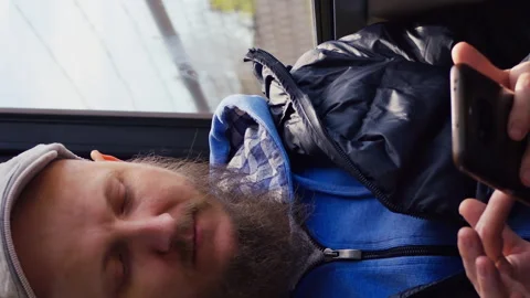 Bearded man using mobile phone in public underground train. Vertical video of Stock Footage 247515114