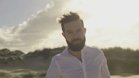 Bearded man is walking with his back and smiling looking at the camera Stock Footage 87145250