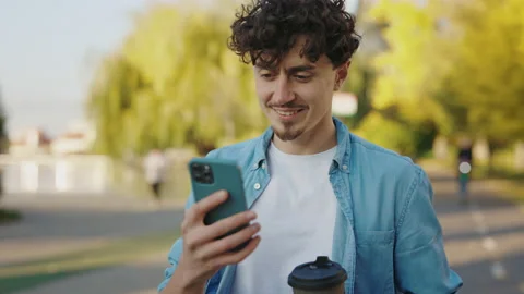 Bearded Man Walking on the Street Using his Smartphone, Texting With Friends Stock Footage 237456315