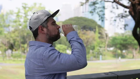 Bearded man wearing cap drinking bottled water. Stock Footage 306647373
