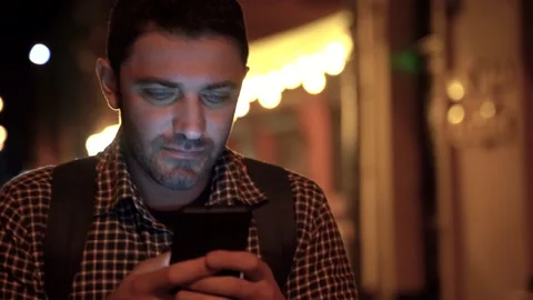 Bearded man wearing casual clothes walking on the urban street at night. Stock Footage 186560176