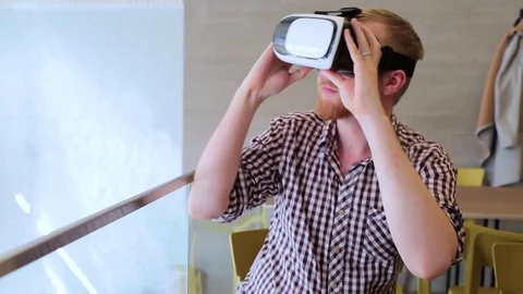 A bearded man wearing virtual reality glasses in the cafe Stockbeeldmateriaal 74443412