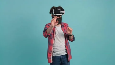 Bearded man wearing virtual reality glasses. Studio shot, turquoise background. Stock Footage 140616316