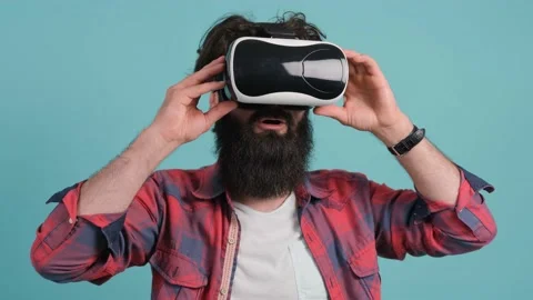 Bearded man wearing virtual reality glasses. Studio shot, turquoise background. Stock Footage 147139011