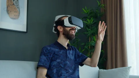 Bearded man wearing a VR headset explores virtual reality experience. Inter.. Vídeos de archivo 282931479