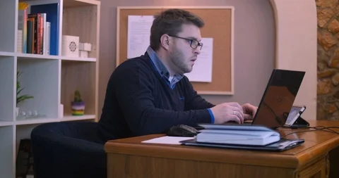 Bearded man working at computer in office Stock Footage 87323968