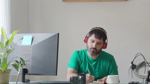 Bearded man working in front of a computer in a modern office Stock Footage 147547870