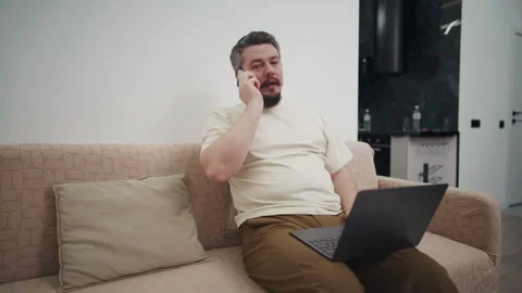 Bearded man working from home talking on the phone Stock Footage 340931034
