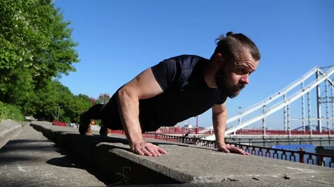 The Bearded Man Is Working Out In Outdoor Urban Environment. Push Ups. Stock Footage 89716152