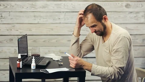 A bearded man works at the computer and coughs. 스톡 동영상 98565863