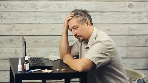 A bearded man works at the computer and coughs. Stock Footage 99882670