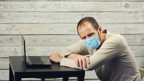 A bearded man works at the computer and coughs. Stock Footage 99941504