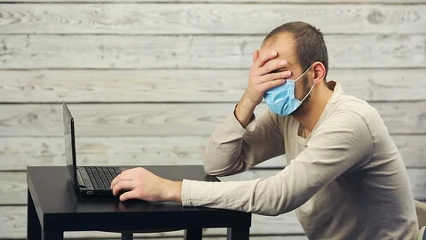 A bearded man works at the computer and coughs. Stock Footage 99941547