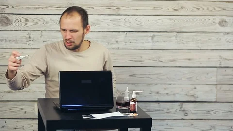A bearded man works at the computer and coughs. Stock Footage 99941852