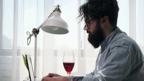 Bearded man that works at the computer full of reminder notes, drink wine. Stock Footage 155641739