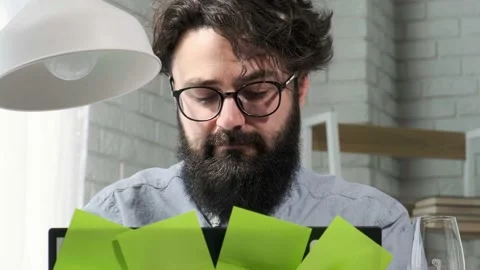 Bearded man that works at the computer full of reminder notes, home office. Stock Footage 155760445