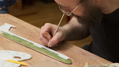Bearded master in glasses colours fuselage between windows Stock Footage 127375608