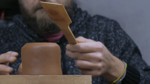 Bearded master makes the mold for the clay teapot with a special wooden spatula Stock Footage 120586499