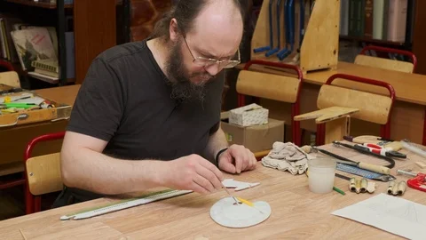 Bearded master sits at table and colours jetliner model 스톡 동영상 127375791