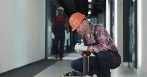 Bearded middle-aged electrical worker in hardhat protective uniform searching Stock Footage 149854116