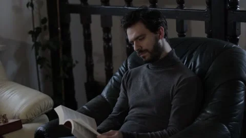 Bearded Middle Aged Man Reading a Book Indoors on an Armchair Stock Footage 237874530