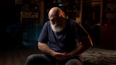 Bearded middle-aged man suffers from stomach pain and rushes to the bathroom Stock Footage 342520690