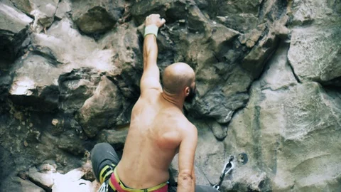 Bearded mountain climber man rises up the rock with the insurance. 4K UHD Stock Footage 103099137