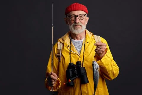 Bearded old attractive man angling fish in pond, posing with Stock Photos