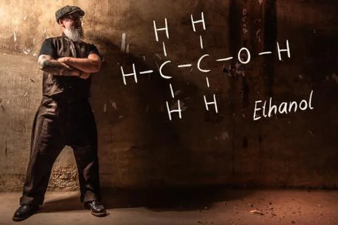 Bearded old man presenting handdrawn chemical formula of ethanol Stock Photos