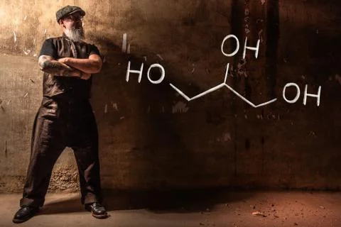Bearded old man presenting handdrawn chemical formula of Glycerol Stock Photos
