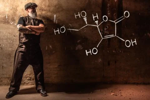 Bearded old man presenting handdrawn chemical formula of Vitamin C Foto stock