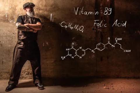 Bearded old man presenting handdrawn chemical formula of Vitamin B9 Stock Photos